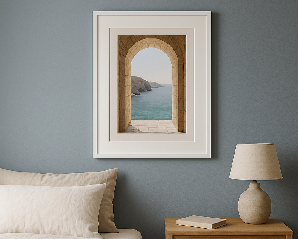 A2 white picture frame with matboard and travel photograph on dusty blue bedroom wall above bedside table